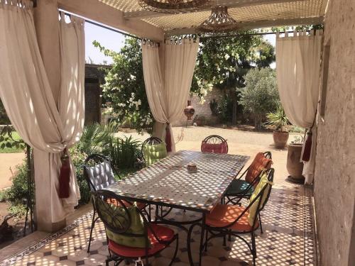 eine Terrasse mit einem Tisch und Stühlen auf einer Terrasse in der Unterkunft VILLA ALWAN BARAKA - Sans vis à vis, Piscine chauffée, Hammam, Personnel in Essaouira