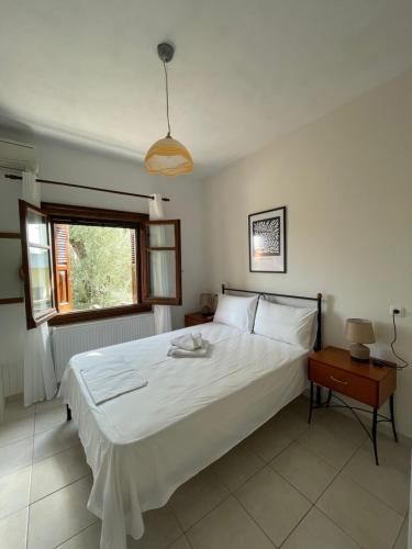 sypialnia z dużym białym łóżkiem i oknem w obiekcie The 3M w mieście Kala Nera