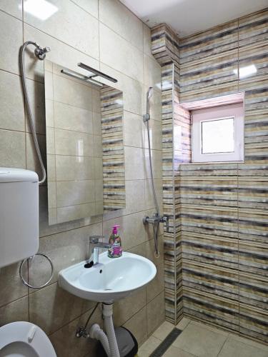 ein Bad mit einem Waschbecken und einer Dusche in der Unterkunft Restoran Lovac in Novi Kneževac