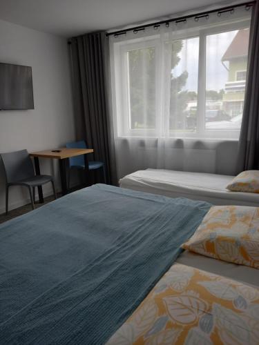 een hotelkamer met twee bedden en een raam bij Dom Hermana in Mrzeżyno