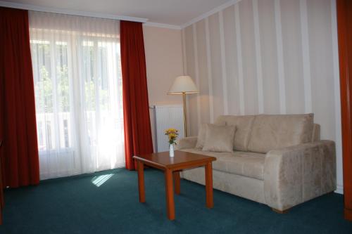 a living room with a couch and a table at Hotel Pension Bellevue in Bad Doberan