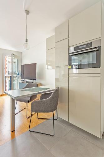 La cuisine est équipée d'une table, de deux chaises et d'un réfrigérateur. dans l'établissement Arc de Triomphe Luxury Place, à Paris