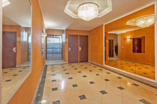 un couloir avec un lustre et une chambre revêtue de carrelage. dans l'établissement Arc de Triomphe Luxury Place, à Paris