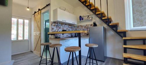 a kitchen with stools and a refrigerator and stairs at Panoramic view with jacuzzi in Vis