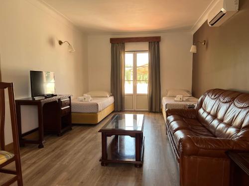 a living room with a couch and a table at Hotel O Gato - Edificio Standard in Odivelas