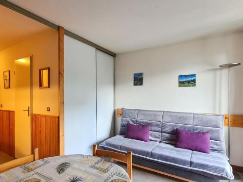 une chambre avec un lit et des oreillers violets dans l'établissement Studio lumineux avec balcon Sud, centre station, 4 pers, casier à ski, proche pistes et commerces - FR-1-425-80, à Flaine