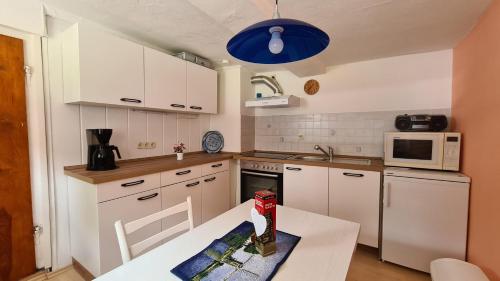 une cuisine avec une table et une lumière bleue dans l'établissement Haus-Hohegeiss-freistehend-und-zentrumsnah, à Hohegeiss
