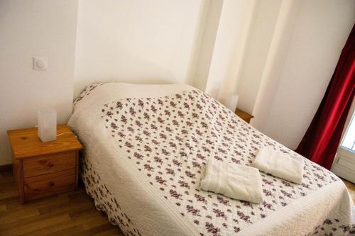 a small bedroom with a bed and a night stand at Hostel Le Diablotin in Saint-Jean-de-Fos