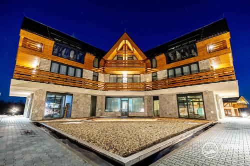 a large building with a stone courtyard in front of it at TATRA SUITES Vila HIMALAYA in Tatranská Lomnica
