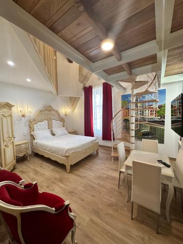 a bedroom with a bed and a table and chairs at Suite Impériale Église du Couvent in Narbonne