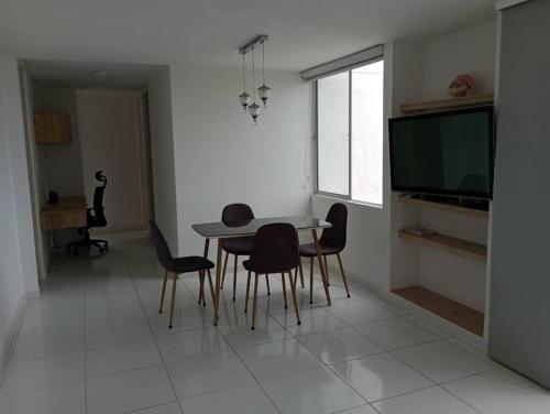 a dining room with a table and chairs and a television at Apto Agradable y Fresco en Conjunto Cerrado Decimo Piso in Neiva