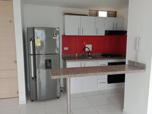 a kitchen with a stainless steel refrigerator and red walls at Apto Agradable y Fresco en Conjunto Cerrado Decimo Piso in Neiva