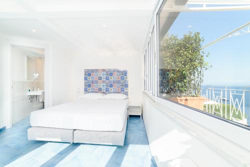 a bedroom with a bed and a large window at Eden sul Mare in Amalfi