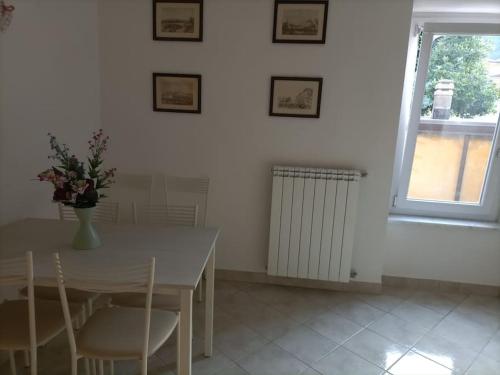 a dining room with a table and chairs and a window at Appartamento Casa Margi in Ameglia