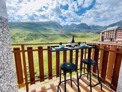 a balcony with a bottle of wine and two stools at Estudio Pas de la Casa Pie de pista-Vistas-Wiffi-Netfli HUT 7353 in Pas de la Casa