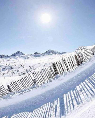 a fence in the snow with the sun behind it at Estudio Pas de la Casa Pie de pista-Vistas-Wiffi-Netfli HUT 7353 in Pas de la Casa