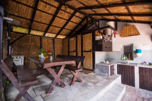 a kitchen with a wooden table and a kitchen with a sink at Pensiunea La Gura Portitei - Jurilovca in Jurilovca