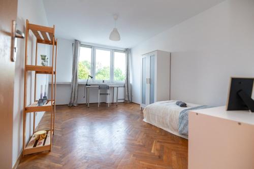 a bedroom with a bed and a desk in it at Regem Pokoje Nowogrodzka in Warsaw