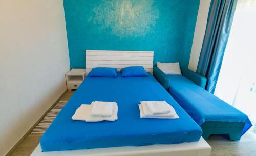 a blue bedroom with a bed with towels on it at Casa Mavi in Vama Veche