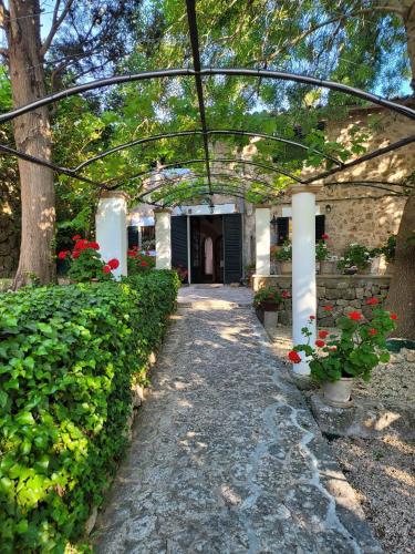 a walkway leading to a building with flowers and plants at Son Niu Vell-La Hermossa in Valldemossa