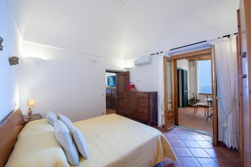 - une chambre avec un lit et une porte donnant sur un balcon dans l'établissement NEW - Golden Hour in Praiano, à Praiano
