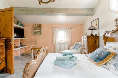 Un dormitorio con una cama con toallas azules. en Agréable chambre d'hôtes avec piscine, en Le Beausset