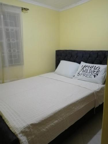 Una cama en un dormitorio con una almohada. en Mwamba Homes, en Kisii