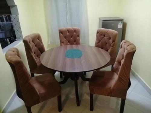 einen Esstisch mit 2 Stühlen und einem Tisch in der Unterkunft Mwamba Homes in Kisii