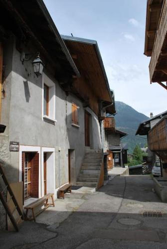 a building with a bench sitting outside of it at Chalet savoyard By the Rock in Villaroger