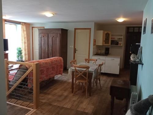 a living room with a table and a kitchen at chez christine in Sainte-Marie