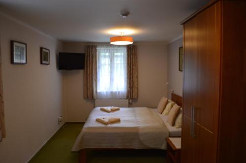 a bedroom with a bed with two towels on it at Hotýlek pod smrkem in Harrachov