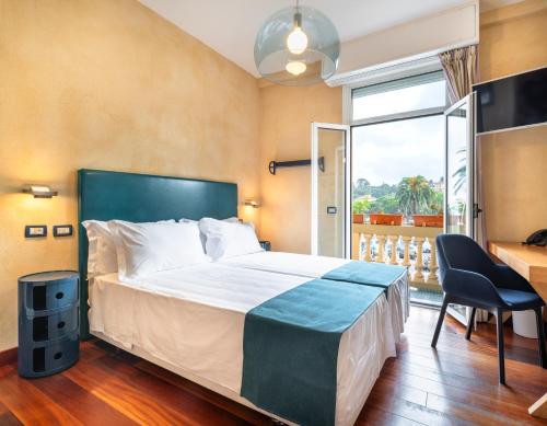 sypialnia z łóżkiem, biurkiem i oknem w obiekcie Hotel Rosa Bianca w Rapallo
