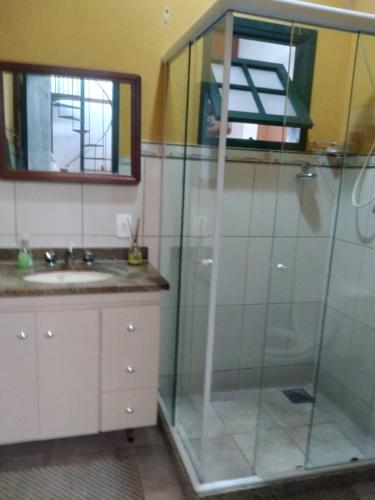 a bathroom with a shower with a sink and a mirror at Guapimirim Casa de Campo in Guapimirim