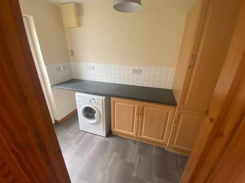 a small kitchen with a washing machine in it at The Meadows 4 bedroom in Buncrana