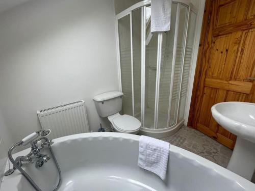 y baño con bañera, lavabo y aseo. en The Meadows 4 bedroom, en Buncrana