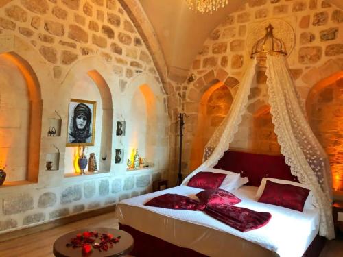 a bedroom with a bed with red pillows on it at Tuğhan Hotel in Mardin