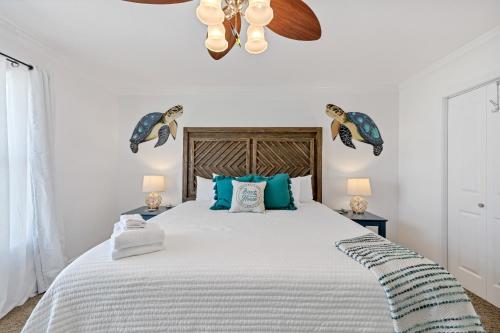 a bedroom with a large bed with blue pillows at The Turtle Dolphin in Port Aransas