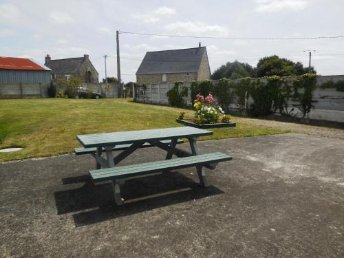 einen Picknicktisch mitten im Garten in der Unterkunft Maison de vacances au calme entre St Malo et Cancale in Saint-Méloir-des-Ondes