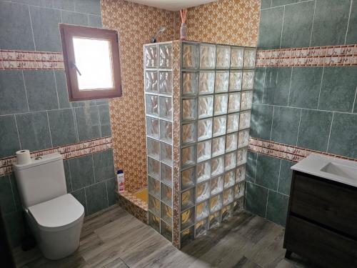 baño con aseo y lavabo y ventana en EL ARA DE LOS ORISHAS, en Siete Aguas