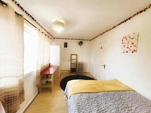 um quarto com uma cama, uma secretária e uma janela em EXCELLENT DOUBLE ROOMS IN CHEAP RATE AROUND CENTRAL LONDON em Londres