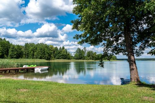 un bateau assis à côté d'un quai sur un lac dans l'établissement Sielska Przystań, à Sucha Rzeczka