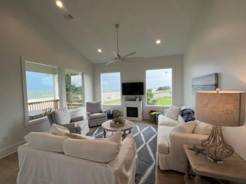 a living room with white furniture and windows at Beauty on the Beach Gulf Luxury w/ Gorgeous Views in Gulfport