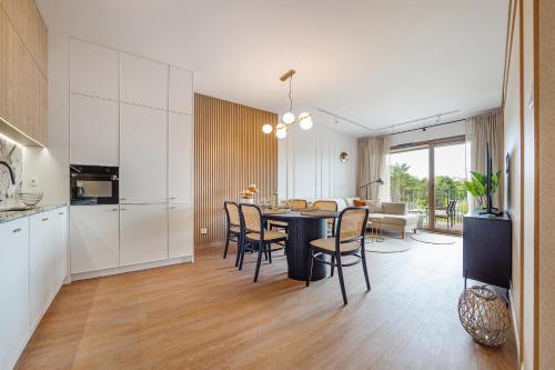 a kitchen and dining room with a table and chairs at Baltica Residence - Premium Apartments in Gdańsk