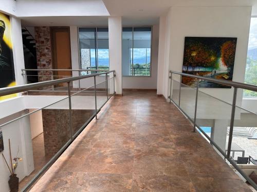 a hallway with glass railings and a painting on the wall at Villa campestre Casa Blanca Full House in Agua de Dios