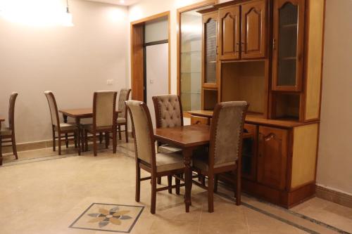 una sala da pranzo con tavoli e sedie in legno di Hayat Grand Guest House a Islamabad