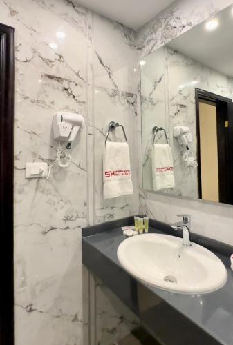 a bathroom with a sink and a mirror at Sedrah Hotel in Irbid