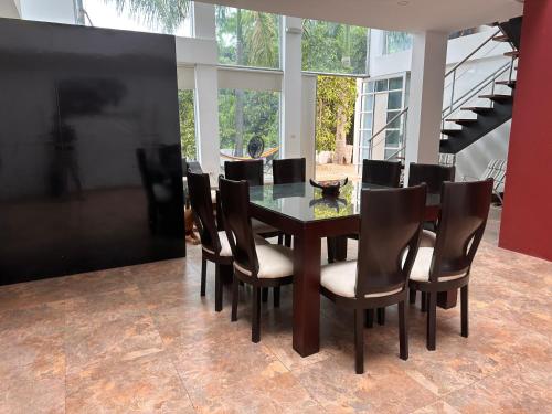 a dining room with a glass table and chairs at Villa campestre Casa Blanca Full House in Agua de Dios