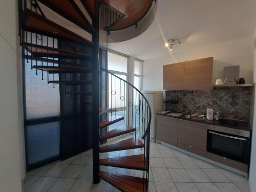 - une cuisine avec un escalier en colimaçon dans une pièce dans l'établissement Terrazza delle rose, à Nettuno