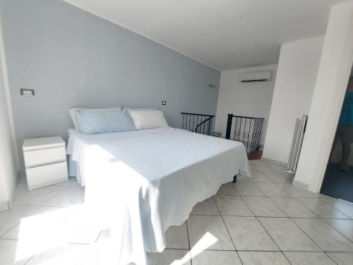 - une chambre blanche avec un grand lit blanc dans l'établissement Terrazza delle rose, à Nettuno