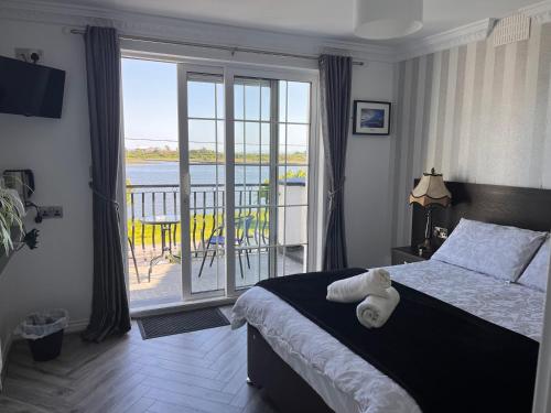 a bedroom with a bed and a balcony with a view at The Light House in Galway